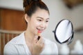 Portrait of a Beauty young woman brunette cosmetics looking in the mirror using red lipstick for beauty lips Royalty Free Stock Photo