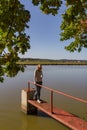 Portrait of beauty young woman standing and looking up on pond jetty, Czech autumn landscape