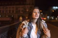 Portrait of a beautyful young brunette girl on evening city background. Attractive young woman on city street Royalty Free Stock Photo