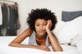 Portrait, bed and black woman waking up, bored and upset with fatigue, lazy and unhappy at home. Face, female person and