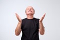 Portrait of begging caucasian man in casual outfit, holding hands in pray and looking up hopefully, praying Royalty Free Stock Photo