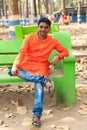 Portrait of a bengali man sitting with his legs crossed and smiling in outdoor