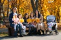 Portrait of big family with children in an autumn city park, happy people sitting together on a wooden bench, posing and smiling, Royalty Free Stock Photo