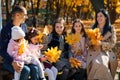 portrait of big family with children in an autumn city park, happy people sitting together on a wooden bench, posing and smiling, Royalty Free Stock Photo