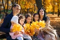 portrait of big family with children in an autumn city park, happy people sitting together on a wooden bench, posing and smiling, Royalty Free Stock Photo