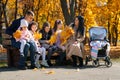 portrait of big family with children in an autumn city park, happy people sitting together on a wooden bench, posing and smiling, Royalty Free Stock Photo