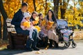 portrait of big family with children in an autumn city park, happy people sitting together on a wooden bench, posing and smiling, Royalty Free Stock Photo