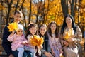 portrait of big family with children in an autumn city park, happy people sitting together on a wooden bench, posing and smiling, Royalty Free Stock Photo