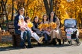 portrait of big family with children in an autumn city park, happy people sitting together on a wooden bench, posing and smiling, Royalty Free Stock Photo