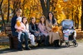 portrait of big family with children in an autumn city park, happy people sitting together on a wooden bench, posing and smiling, Royalty Free Stock Photo