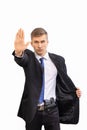 Portrait of young attractive serious security business man with gun in dark suit and bright blue tie, isolated on white Royalty Free Stock Photo