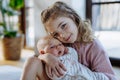 Portrait of big sister holding newborn sister. Girl carefully cuddling small baby. Sisterly love, joy for new family Royalty Free Stock Photo