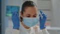 Portrait of biologist taking off face mask in laboratory