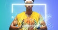 Portrait of biracial basketball player holding ball in front of illuminated rectangle and plants Royalty Free Stock Photo