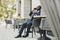 Portrait of a black African American businessman in a suit sitting in a city cafe outdoors and talking on the phone. Royalty Free Stock Photo