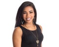 Portrait of Black brazilian woman with a long straight hair looking at camera with joyful smile. Isolated on white background