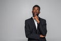 Portrait of black businessman with suit thinking over gray background Royalty Free Stock Photo