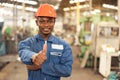 Portrait of a black factory worker in a hardhat staring at the photo while standing in a workshop, copy space, and factory Royalty Free Stock Photo