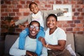 Portrait of black family in home, parents and kid on sofa with piggy back, bonding and relax in lounge. Mom, dad and Royalty Free Stock Photo