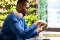 Portrait of black guy listening to music at cafe Royalty Free Stock Photo