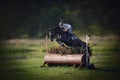 Black horse with woman rider jumping over obstacle during eventing cross country competition in summer Royalty Free Stock Photo