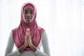 Portrait Of Black Islamic Lady In Hijab Praying Near Window At Home
