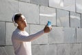 Portrait of black latin guy with headphones taking a selfie on the street with his cell phone Royalty Free Stock Photo