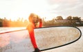 Portrait of black long-haired teen boy with a surfboard ready for surfing with sunset backlight. He walking into Indian ocean Royalty Free Stock Photo