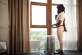 Portrait of a black man businessman with packed suitcase near large window in hotel room