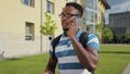 Portrait of black man student having phone talk outdoor. Cheerful student talking on smartphone on urban street. Royalty Free Stock Photo