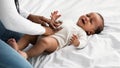 Portrait of black mother doing belly massage for crying baby Royalty Free Stock Photo