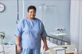 Black senior woman standing by bed in hospital room and looking at camera Royalty Free Stock Photo