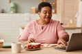 Black senior woman using laptop during breakfast Royalty Free Stock Photo