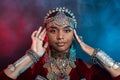 Portrait of a black-skinned teenager in festive oriental jewelry made of metal in the studio on a dark background