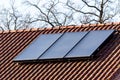 A portrait of black solar panels installed on an orange tiled roof providing the owner of clean energy or electricity while being Royalty Free Stock Photo