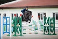 Black stallion horse and handsome man rider jumping obstacle Royalty Free Stock Photo