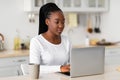 Portrait of black woman sitting at desk working on laptop Royalty Free Stock Photo