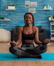 Portrait of black woman smiling practicing yoga at home