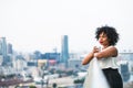 A portrait of a woman standing on a terrace, holding a cup of coffee. Royalty Free Stock Photo