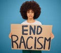 Portrait of a black woman with a stop racism banner and peacefully protesting for human rights in studio. Young afro