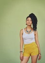 Portrait of black woman, urban fashion and model posing on green wall of studio background for trendy African style Royalty Free Stock Photo
