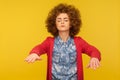 Portrait of blind curly-haired woman with outstretched hands walking alone with closed eyes