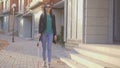 Portrait of a blind girl with a cane walking down the street