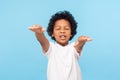 Portrait of blind little curly boy walking with closed eyes and outstretched hands