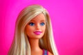 Portrait of blond Barbie doll against pink background