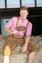 Blond bavarian man sitting on a haystack Royalty Free Stock Photo