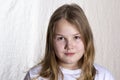 Portrait of blond beautiful girl 10 years old in front on light background, looking at camera, closeup Royalty Free Stock Photo