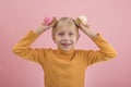 Portrait of blond boy in bright clothes with cupcakes in his hands on pink background. Childrens party with sweets Royalty Free Stock Photo