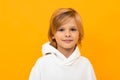 Portrait of blond boy grimacing on yellow studio background close-up Royalty Free Stock Photo