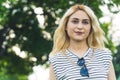 portrait of a blond Caucasian girl looking ahead at the view and smiling. medium closeup green background outdoors Royalty Free Stock Photo